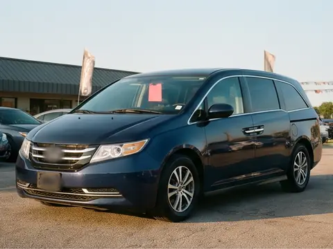 A dark blue 2015 minivan on the lot. Sample photo.